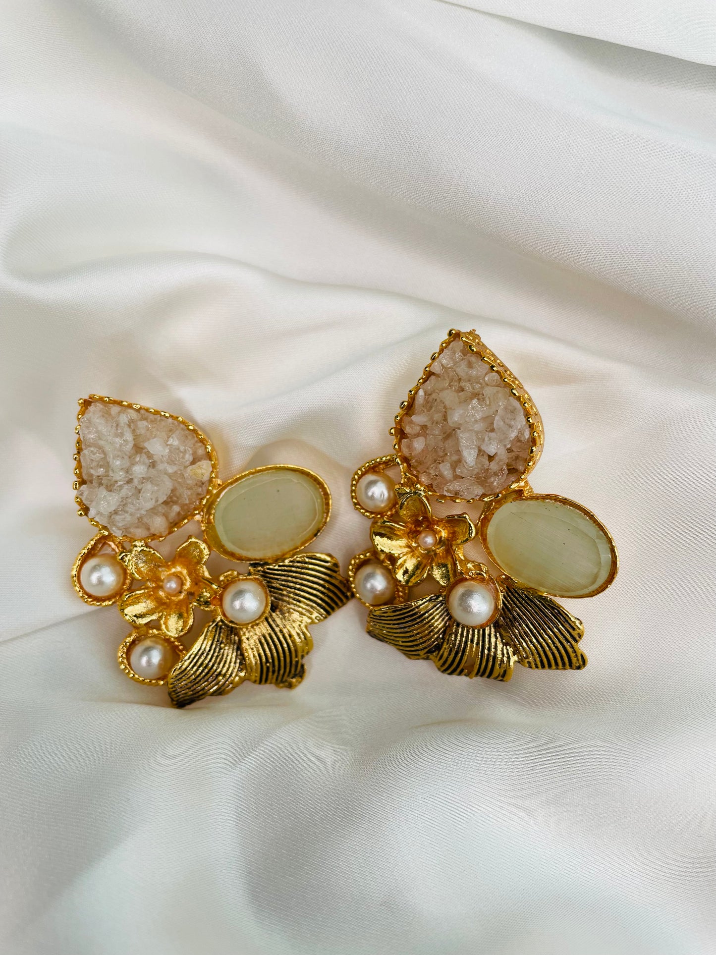 Heavy golden eastern statement earrings in leaf shape embellished with Light Mint stone and White crushed stones along with pearls to compliment with your eastern look.