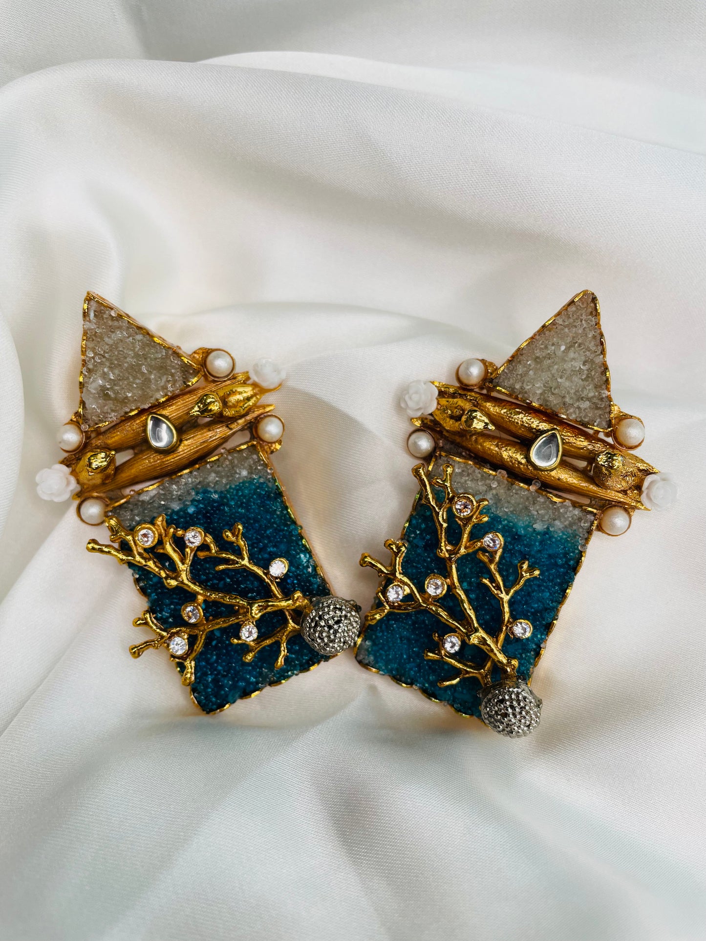 Heavy golden eastern statement earrings embellished with Teal Blue and White crushed stones along with pearls and stones to compliment with your eastern look.